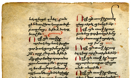 The upper part of the verso of Leaf II shows the dirty, worn, and stained upper margin, the 2 columns of text in bolorgir minuscule script, enlarged initials in metallic red pigment (partly blackened through oxidation over time), section-ending markers in vegetal red pigment (still bright), and a distinctly elongated ascender for one letter in the top line.