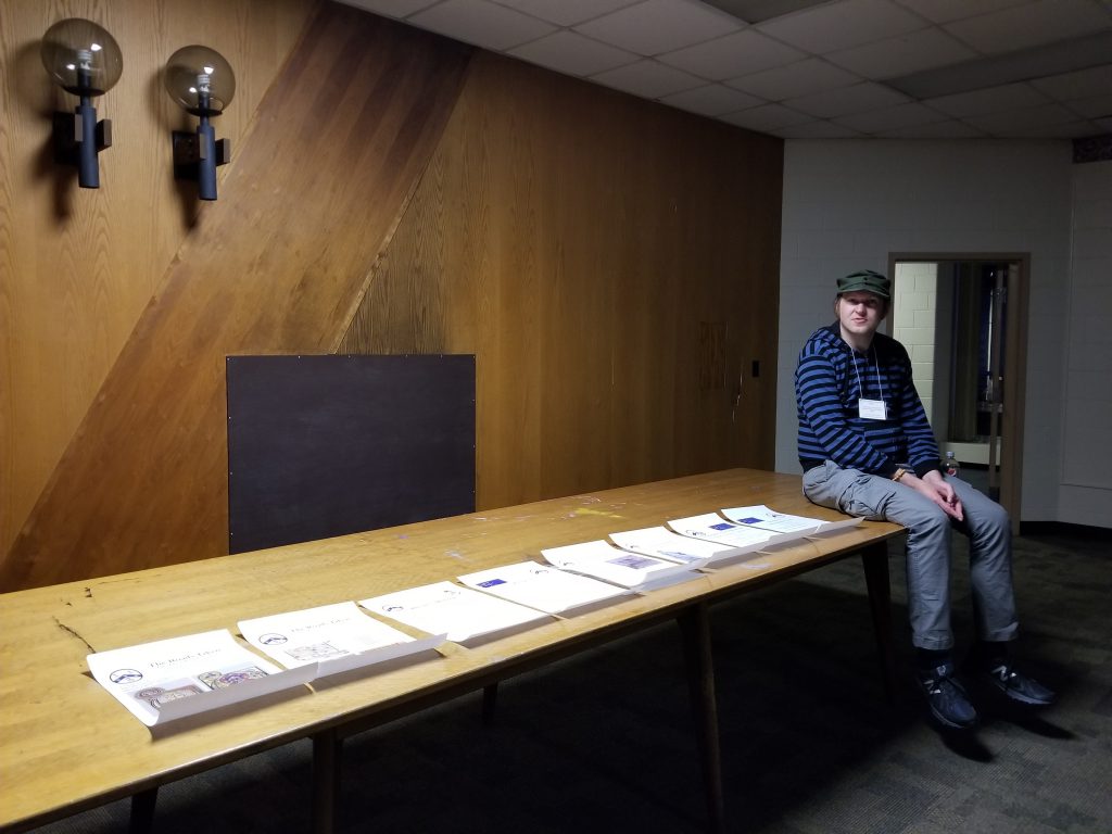 Phillip sits in the Board Room alongside the Research Group Posters for the 2019 Congress. Photograph by Mildred Budny.